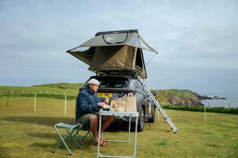 Picnic next to a roof tent on a car into the wild Norway